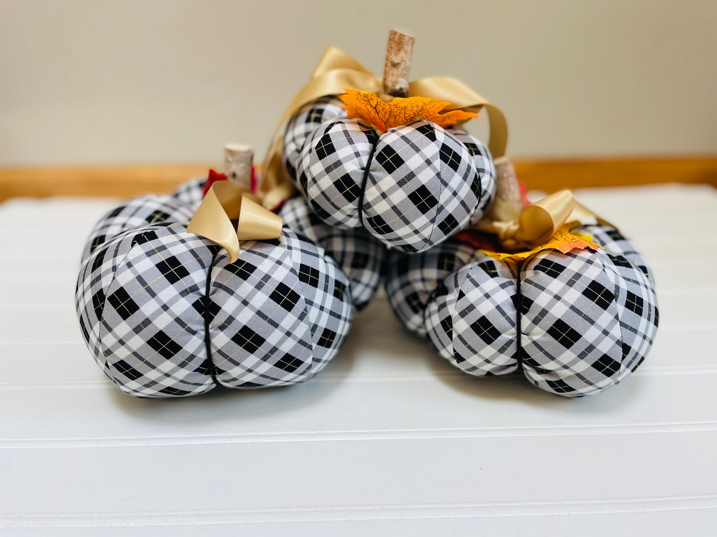 Introducing our set of 3 fabric pumpkins, available in large, medium, and small sizes. These pumpkins are made from a unique black, white and gold plaid fabric, ad