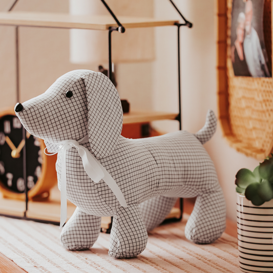 Custom memory dachshund stuffed animal made from black and white grid-patterned fabric, personalized keepsake dog with button eyes and white ribbon, handmade memorial pet loss gift from loved one’s clothing.