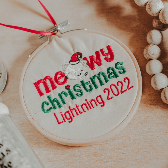 This ornament is perfect for the cat lover in your life! It features an embroidered design of a cat and the words "Meowy Christmas" in an embroidery hoop. The orname