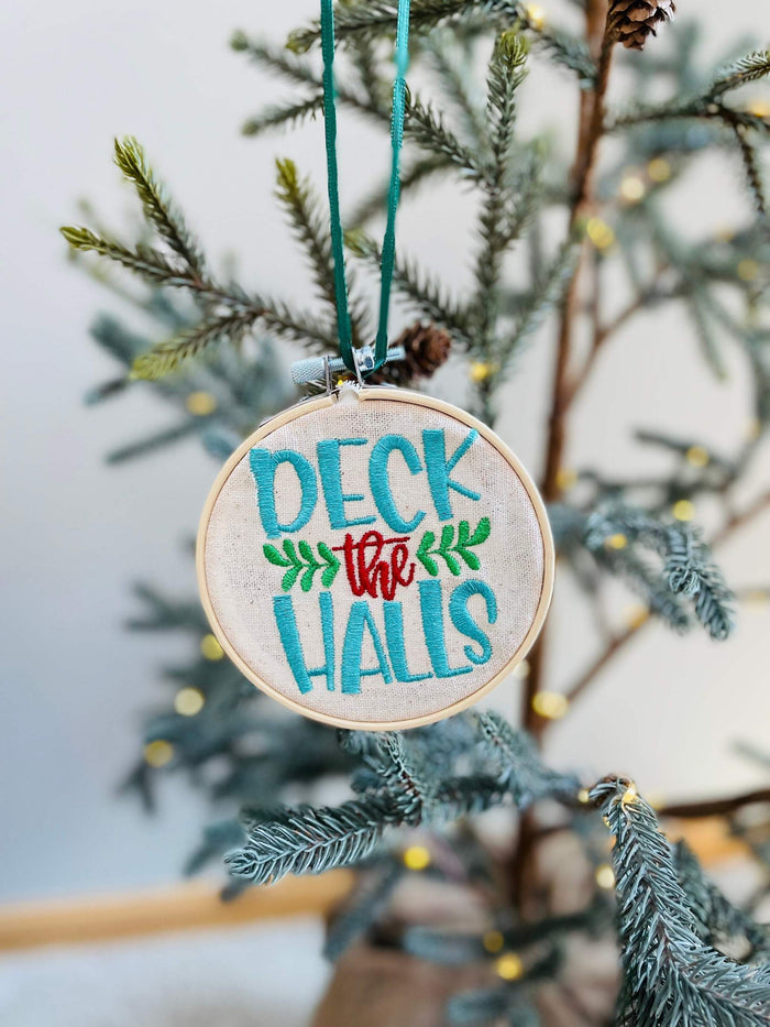 






This ornament features the words "Deck The Halls" embroidered on a 4 inch circle, enclosed in an embroidery hoop. It comes with a satin ribbon hanger, making 