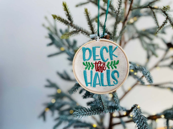 






This ornament features the words "Deck The Halls" embroidered on a 4 inch circle, enclosed in an embroidery hoop. It comes with a satin ribbon hanger, making 