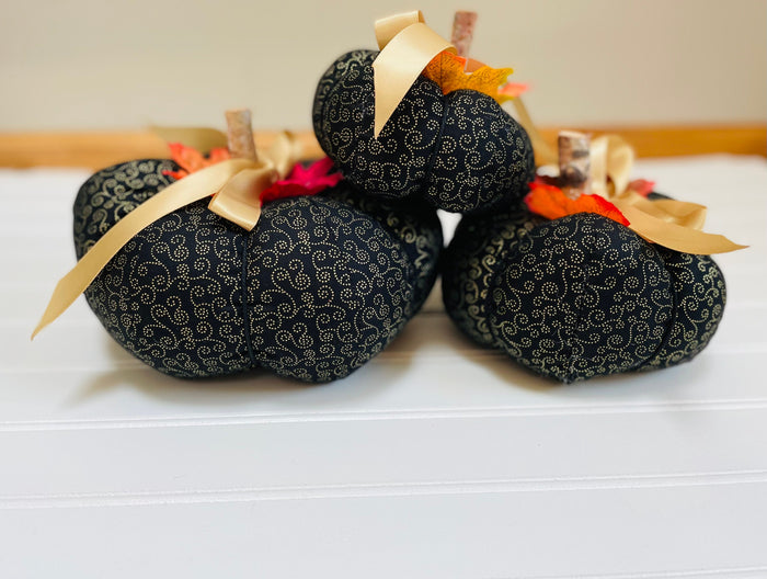 Introducing our set of 3 fabric pumpkins, available in large, medium, and small sizes. These pumpkins are made from a unique black and gold swirled fabric, adding a 