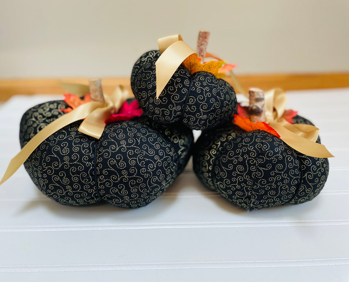 Introducing our set of 3 fabric pumpkins, available in large, medium, and small sizes. These pumpkins are made from a unique black and gold swirled fabric, adding a 